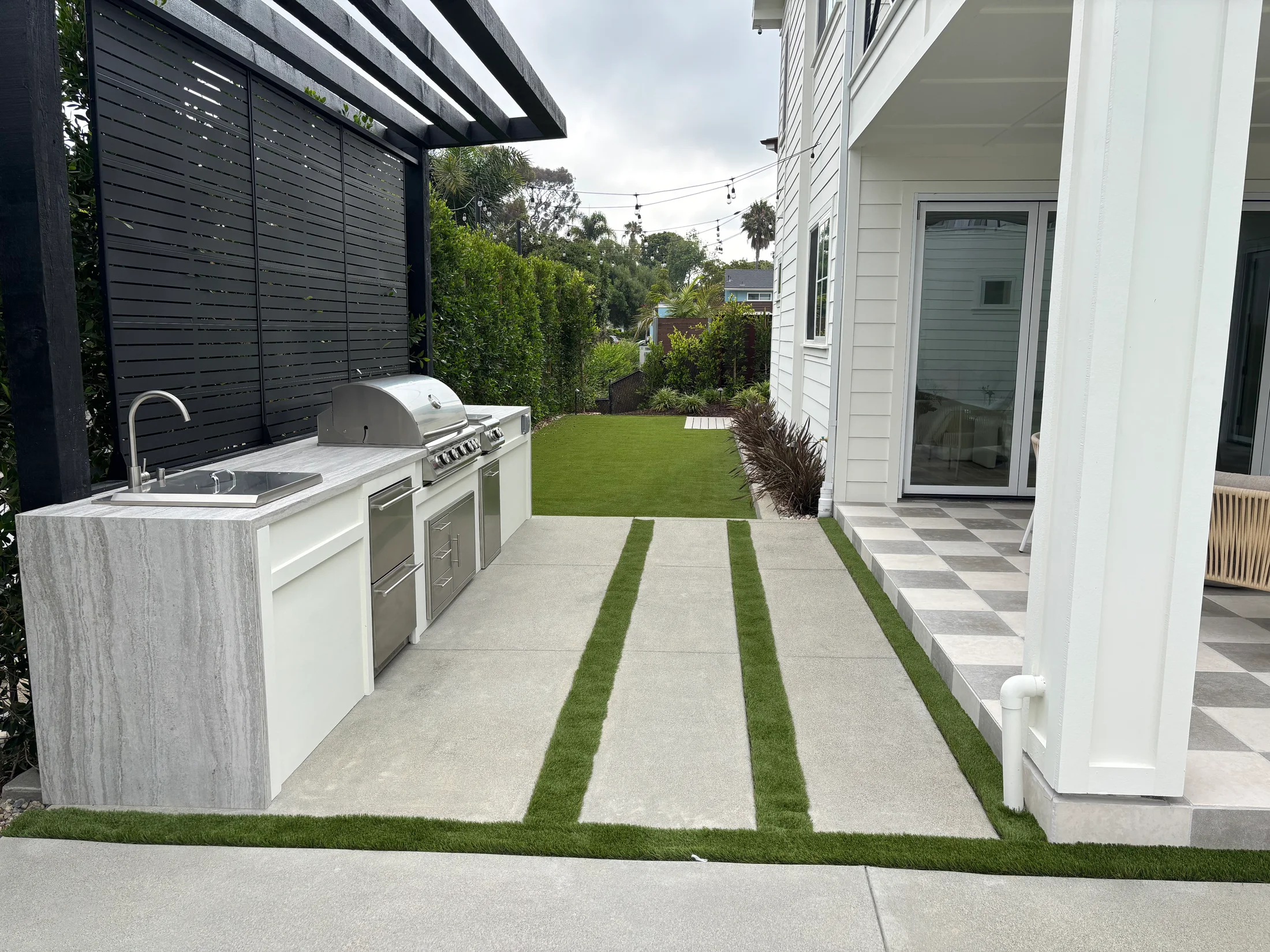 Coastal modern farmhouse backyard with outdoor kitchen and checkerboard patio
