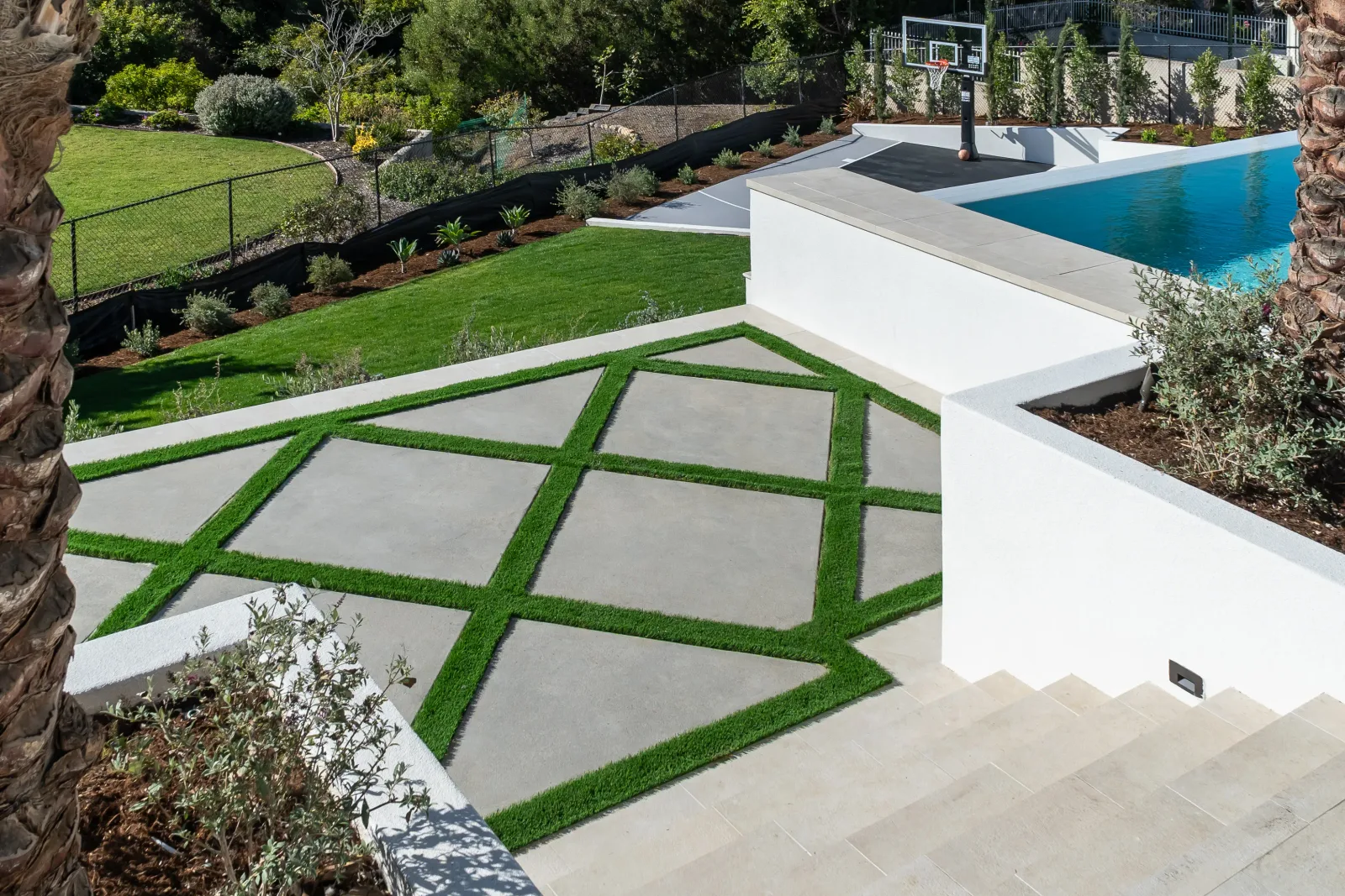 Large Escondido backyard with paver patio, retaining walls, and drought-tolerant planting on an inland rural-residential lot